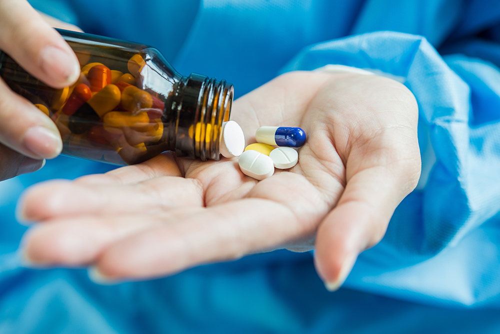 woman-s-hand-pours-medicine-pills-out-bottle.jpg