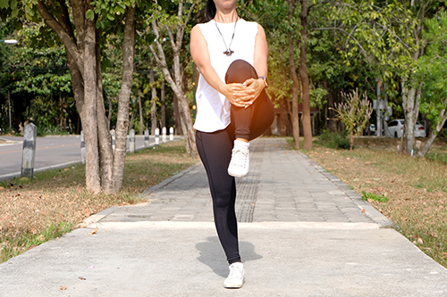 low-section-young-woman-stretching-while-standing-footpath.jpg